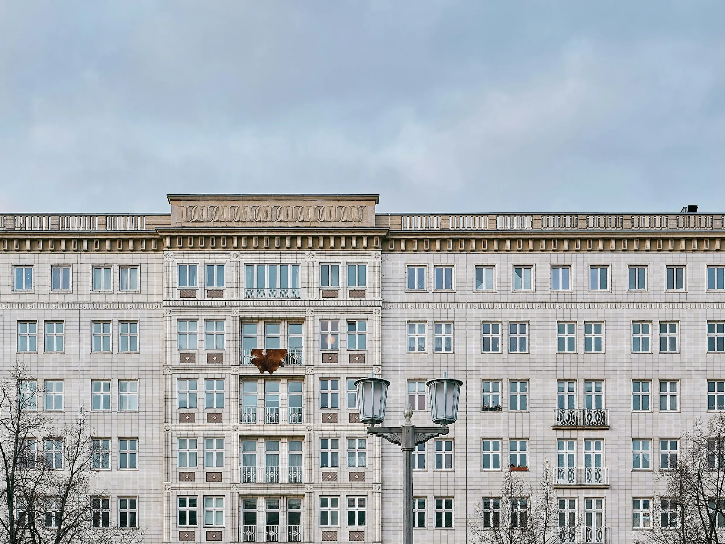 Symmetrische Wohnhausfassade am Frankfurter Tor in Berlin mit gleichmäßig gereihten Fenstern und Balkonen