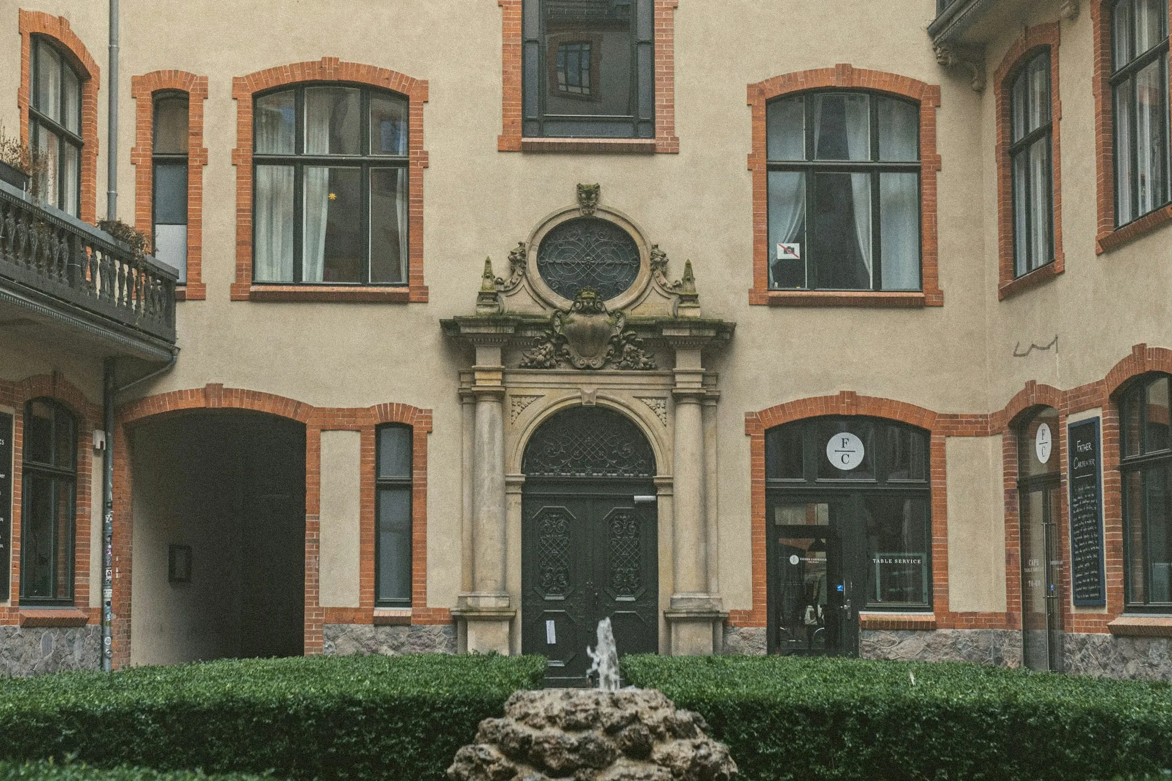 Innenhof eines Berliner Altbaus mit Tordurchfahrt, Sandsteinportal und Brunnen