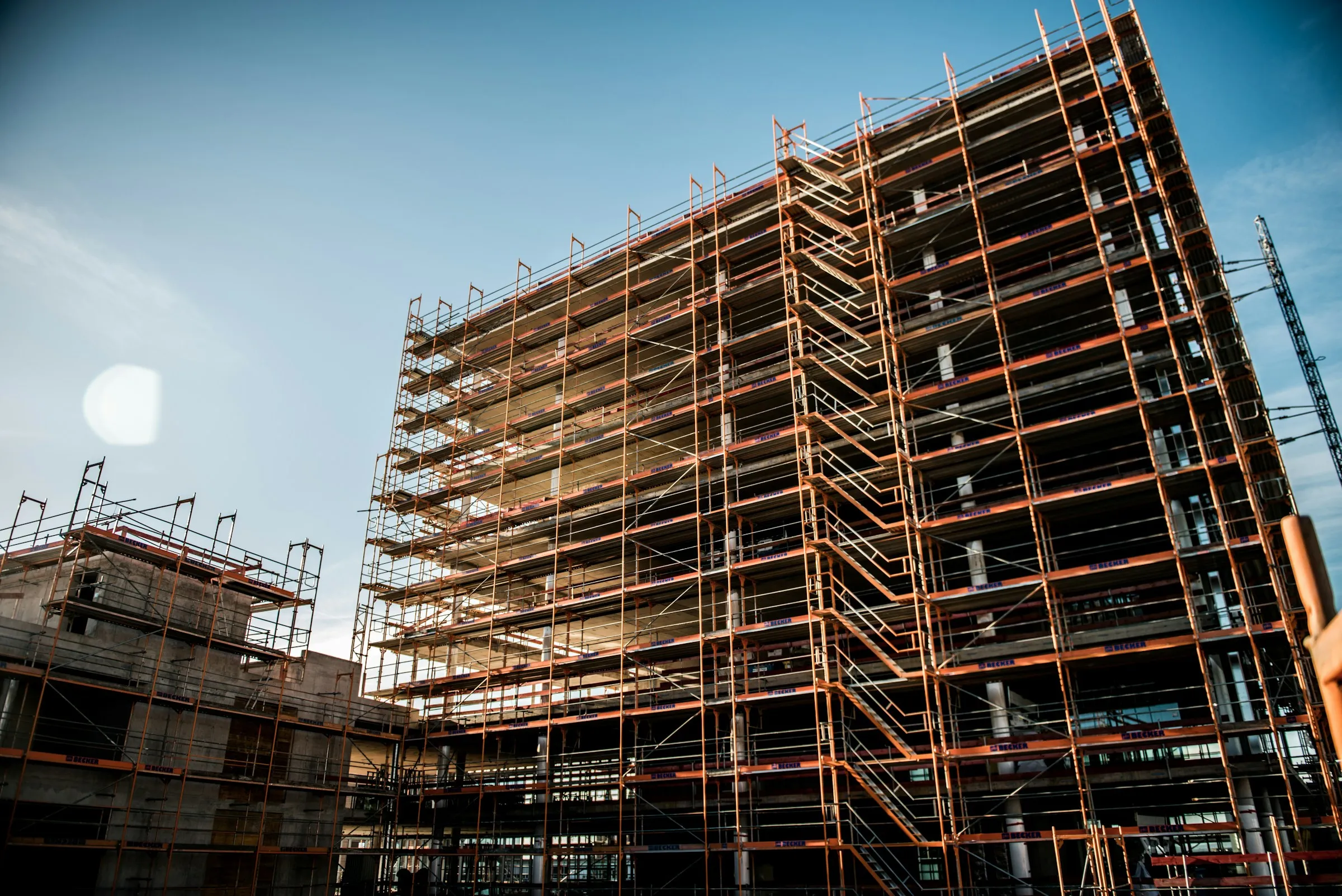 Neubau eines Wohn- und Geschäftshauses, vollständig eingerüstet, vor hellem Himmel